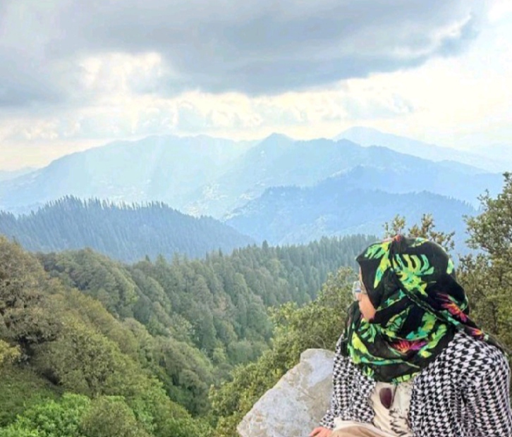 Profile photo of the site owner looking over a scenic mountain landscape